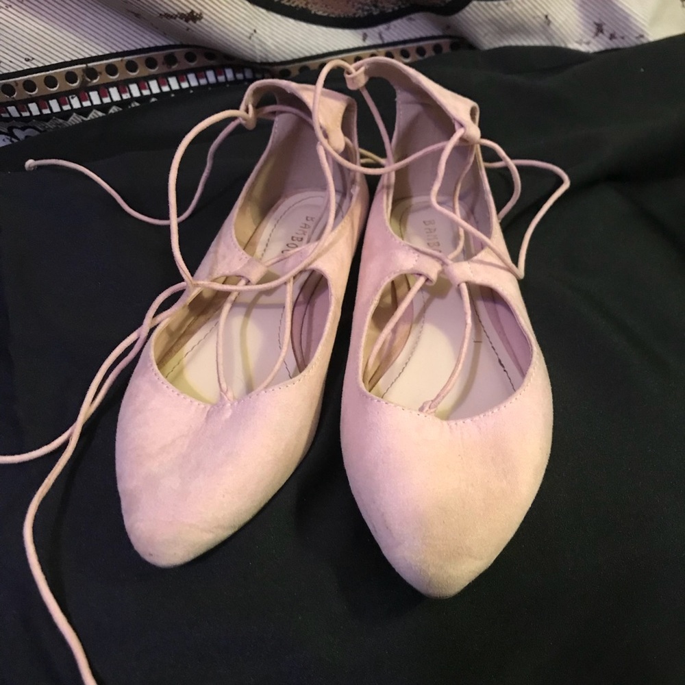 Light pink flats with laces tying up the ankle.